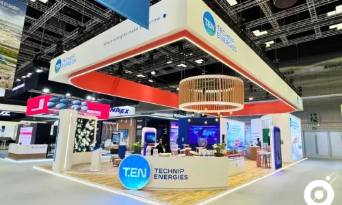 echnip Energies exhibition stand at LNG 2026 Qatar featuring large hanging branding element, open layout, and integrated lighting design.