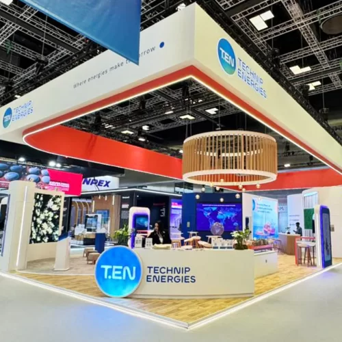 echnip Energies exhibition stand at LNG 2026 Qatar featuring large hanging branding element, open layout, and integrated lighting design.